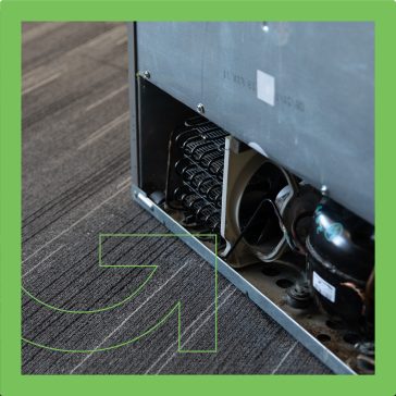 Arrière d’un réfrigérateur montrant le compresseur et les serpentins de refroidissement.